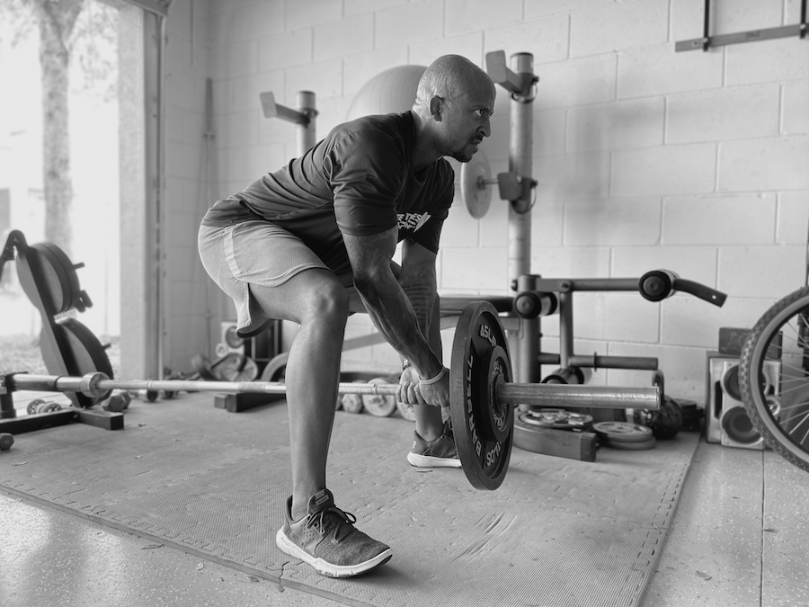 Allen Hamlette performing landmine rows in a black and white photo.