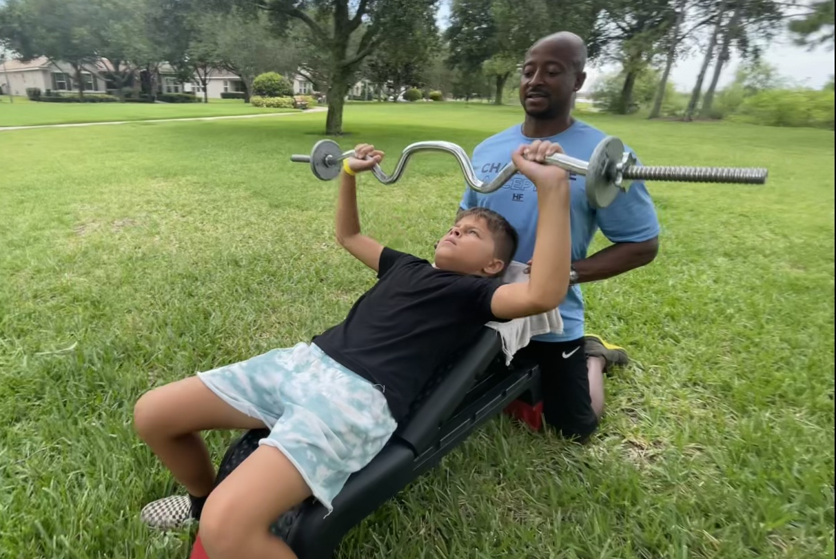 Ozzie performing bench press with Allen spotting.