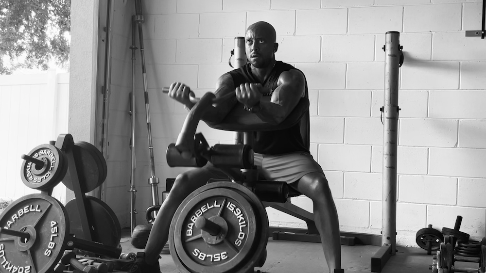 Allen Hamlette performing preacher curls in a black and white photo.